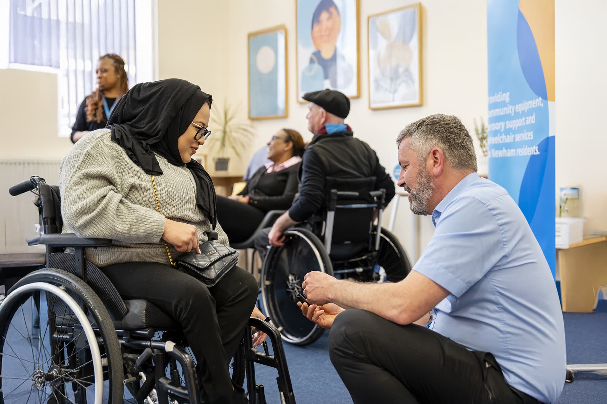 A woman in her wheelchair speaking with an engineer